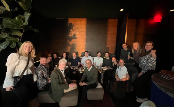 A group of Newcastle alumni smiling to camera at an event in America